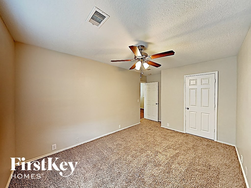 a bedroom with a ceiling fan and a white door