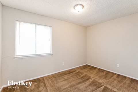 the living room of a home with a carpeted floor and a window