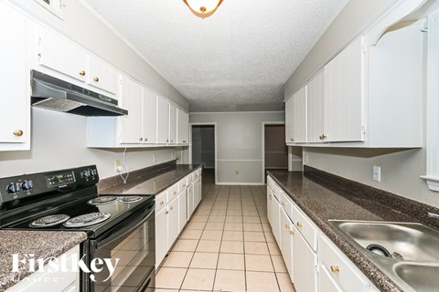 A kitchen with white cabinets and a granite counter top.