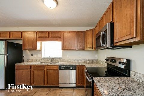 a kitchen with wood cabinets and black appliances and granite counter tops