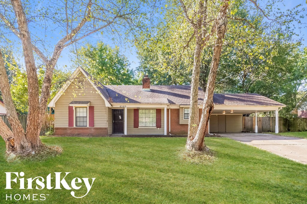 a house with a yard and trees in front of it