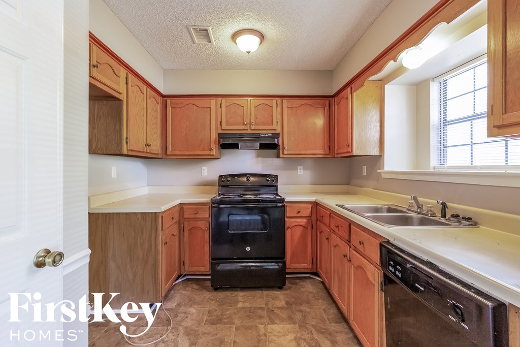 a kitchen with wooden cabinets and a stove and a sink