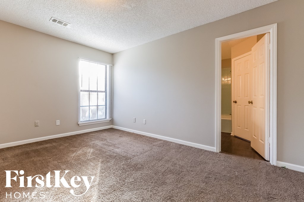 a bedroom with carpet and a door to a closet