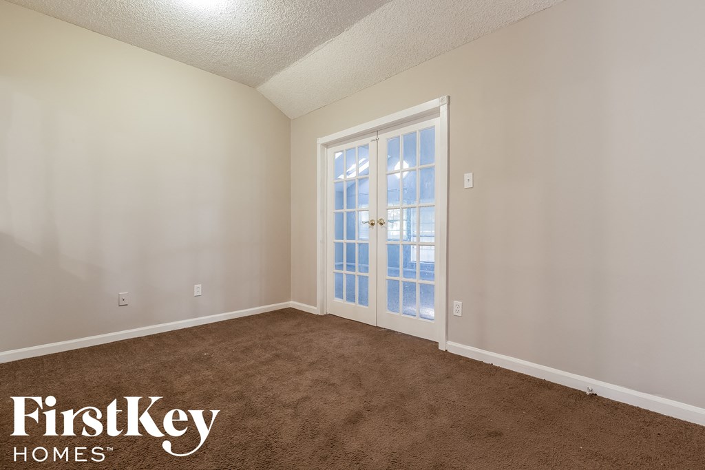 the living room of a home with a carpeted floor and a glass door