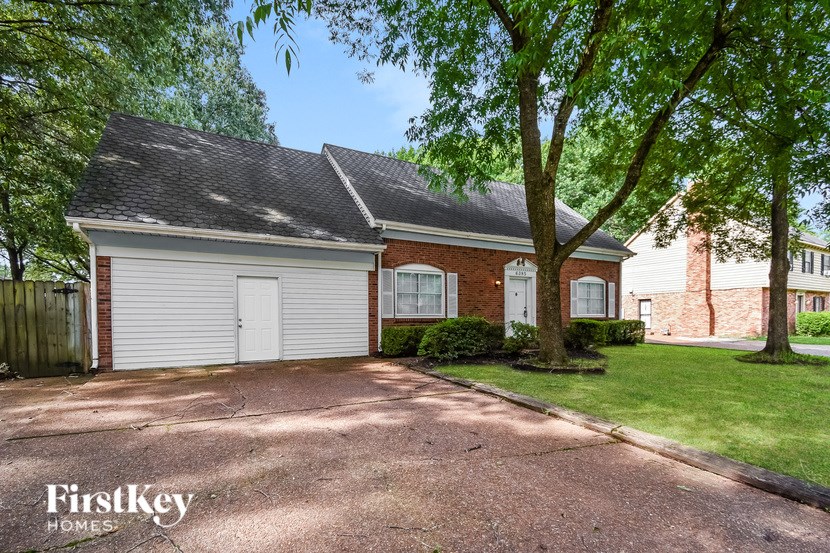 A brick house with a garage door is for sale.