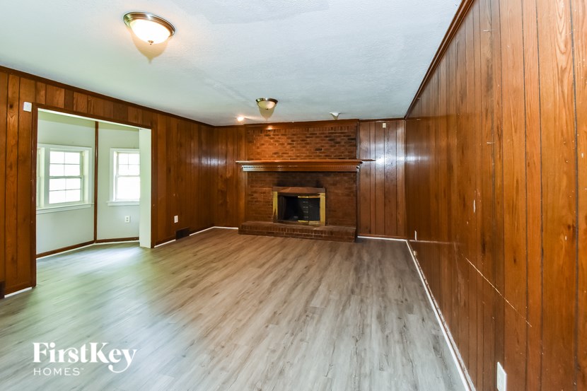 A wooden room with a fireplace and a window.