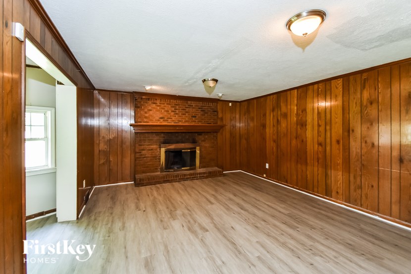 A room with wooden walls and a fireplace.