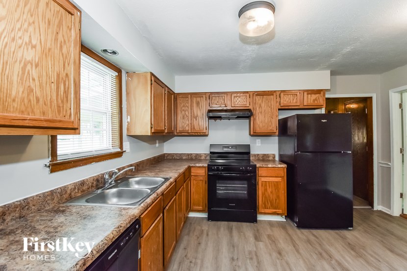 A kitchen with wooden cabinets and black appliances.