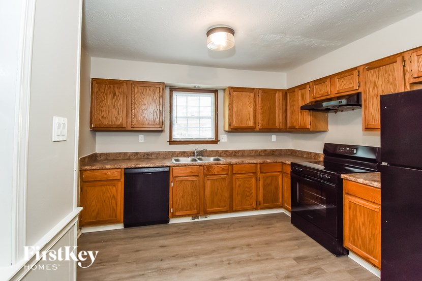 A kitchen with wooden cabinets and black appliances.