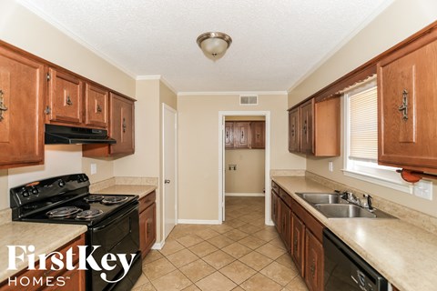 A kitchen with brown cabinets and a black stove top oven.