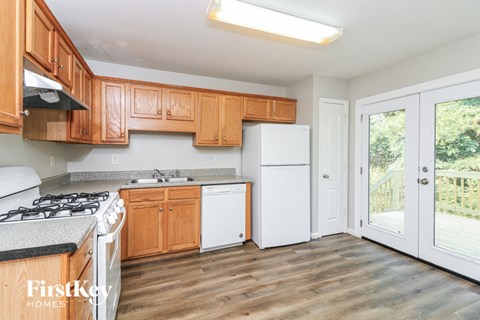 A kitchen with wooden cabinets and a white fridge.
