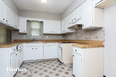 a kitchen with white cabinets and a counter top