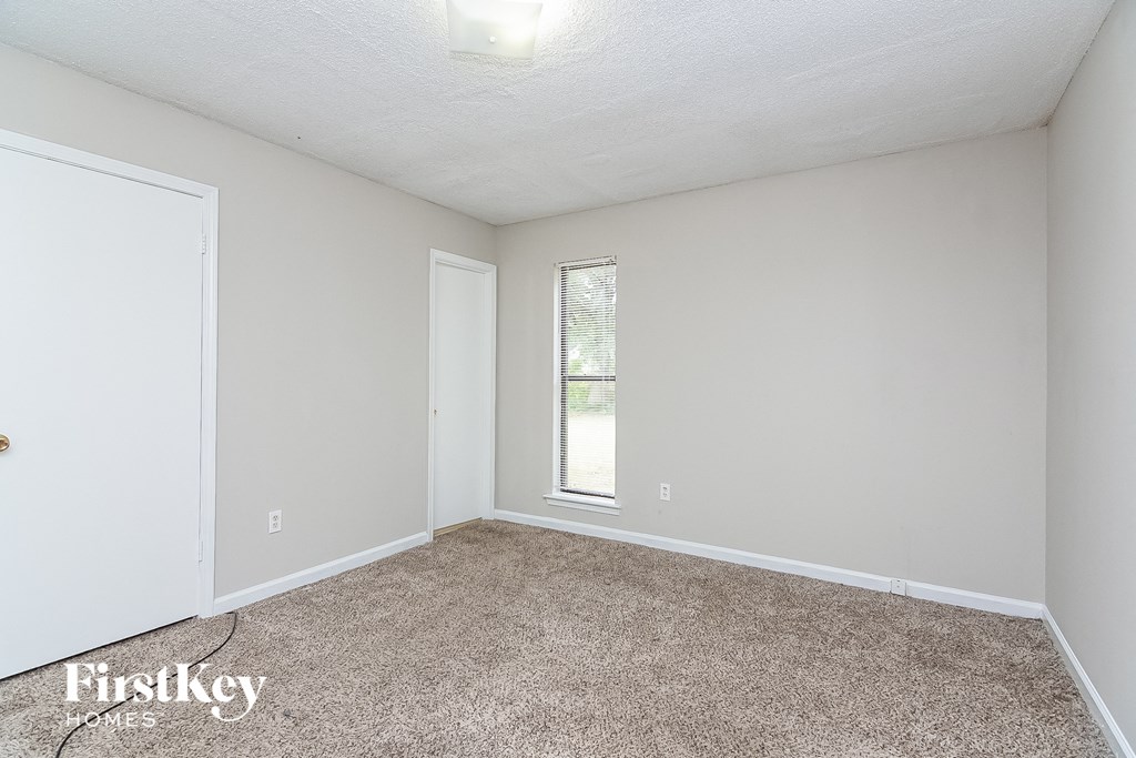 a bedroom with a carpeted floor and a window