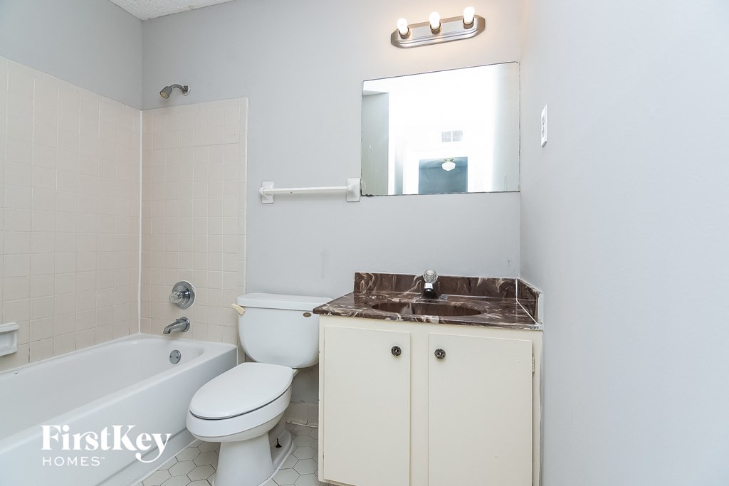 a white bathroom with a sink toilet and a bath tub