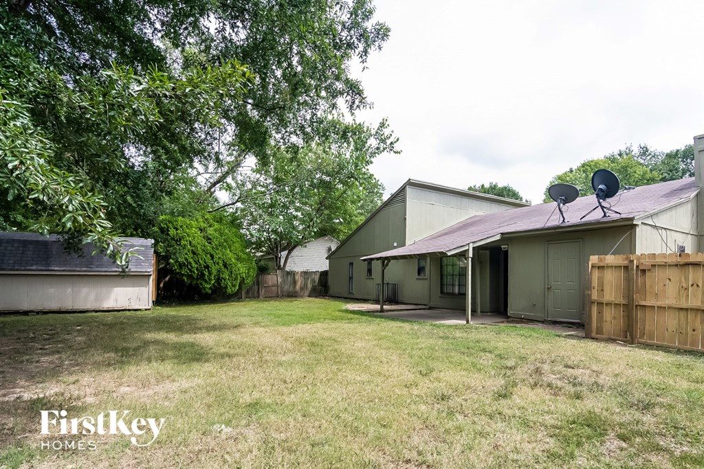 a backyard with a house and a yard and a satellite dish