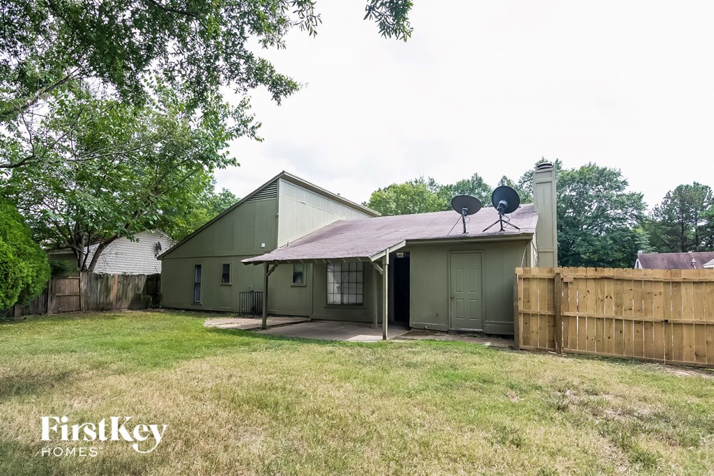 a backyard with a green house and a fence