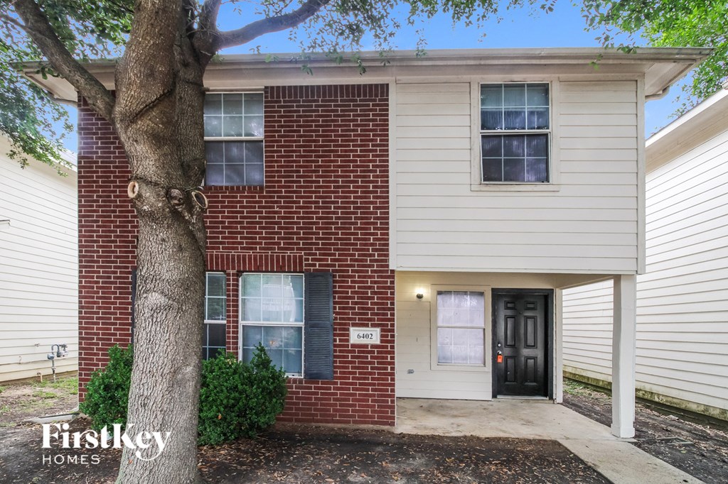 a brick and with a tree in front of it
