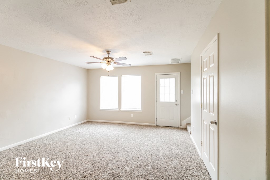 a empty living room with a ceiling fan