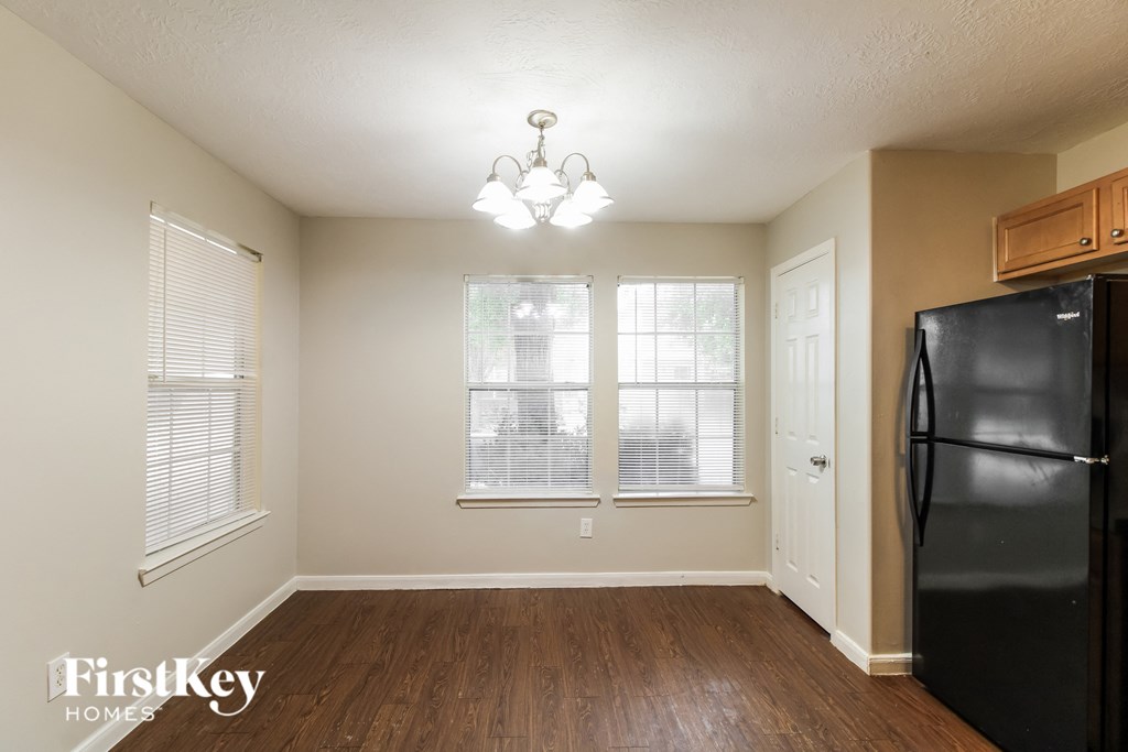 a kitchen with a black refrigerator and a window
