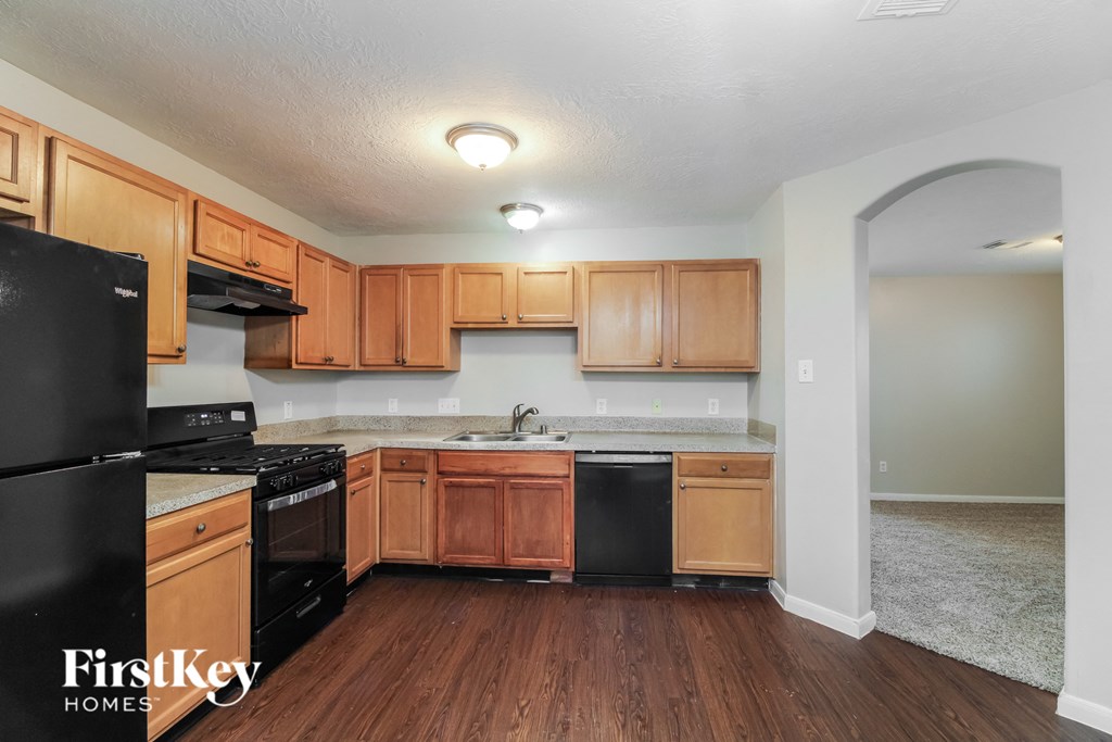a kitchen with wooden cabinets and black appliances