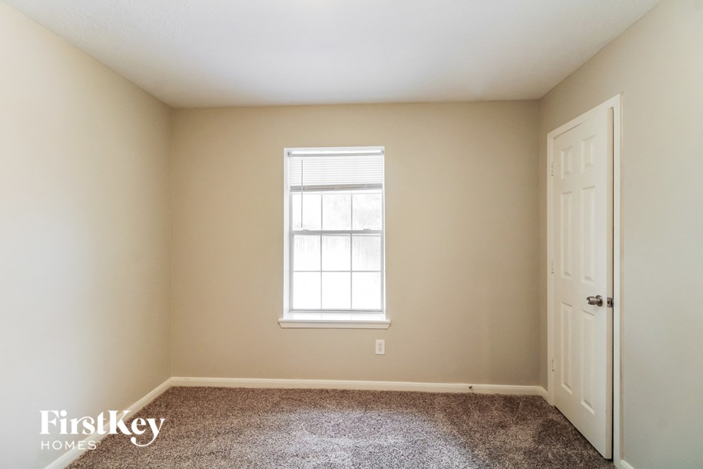 a room with carpet and a window and a door