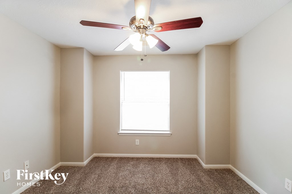 a bedroom with a ceiling fan and a window