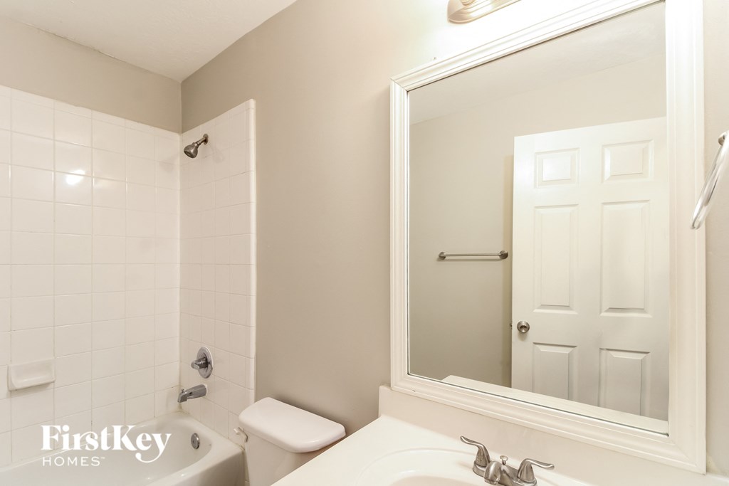 a bathroom with a sink toilet and a mirror