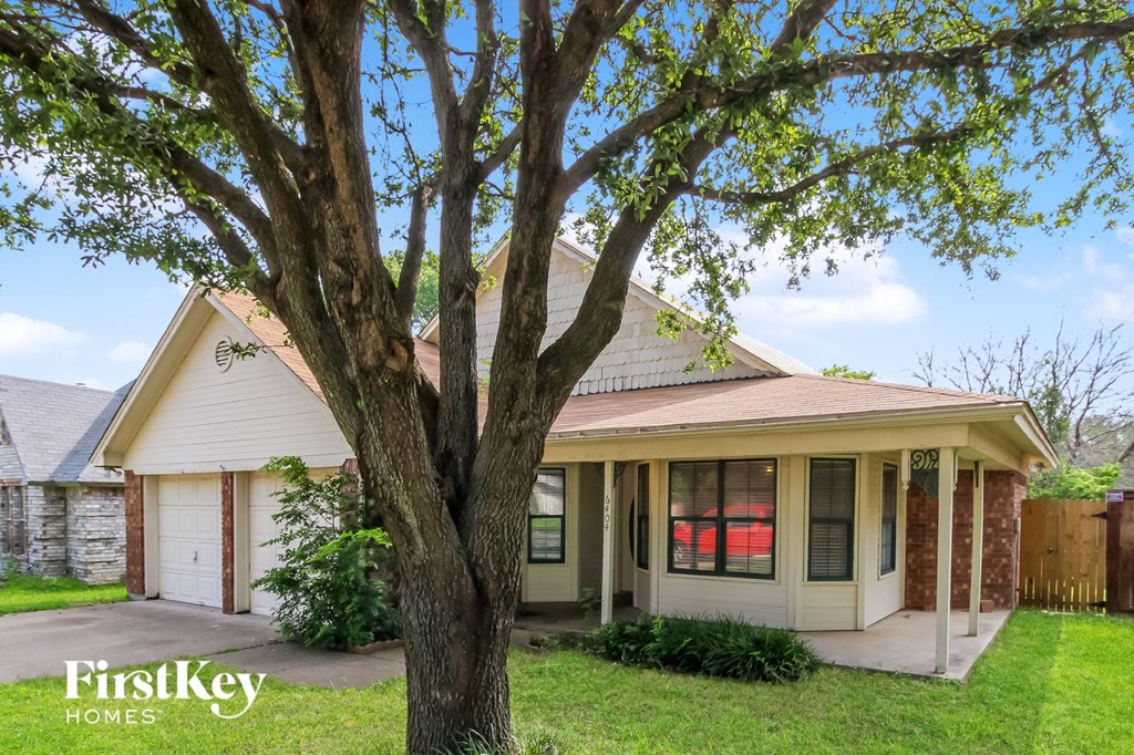 a small white house with a tree in front of it