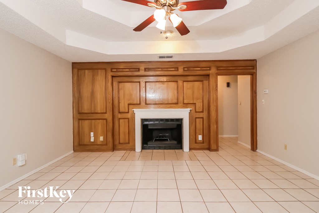 a living room with a fireplace and a ceiling fan