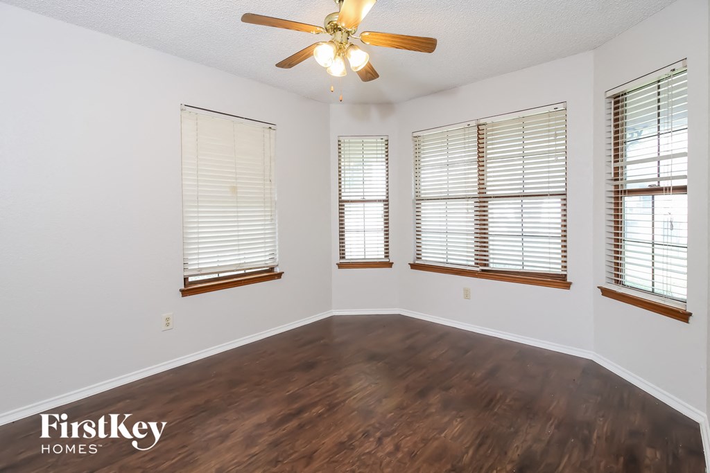 a living room with wood floors and a ceiling fan