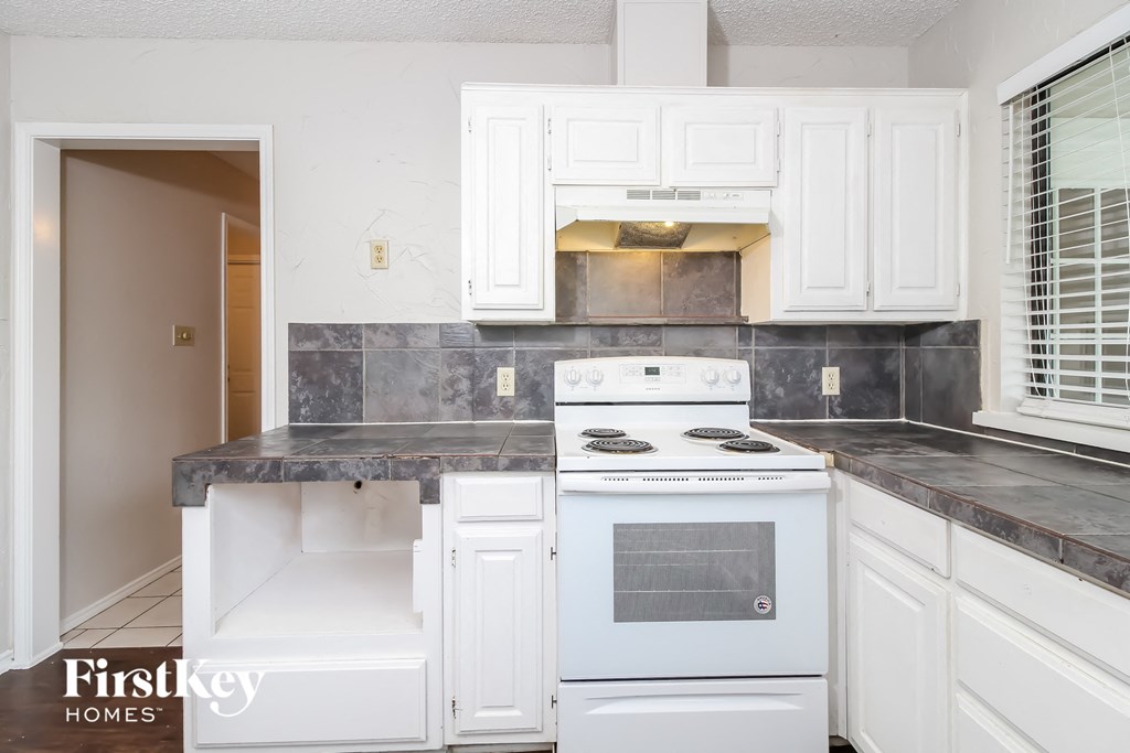 a white kitchen with white appliances and white cabinets