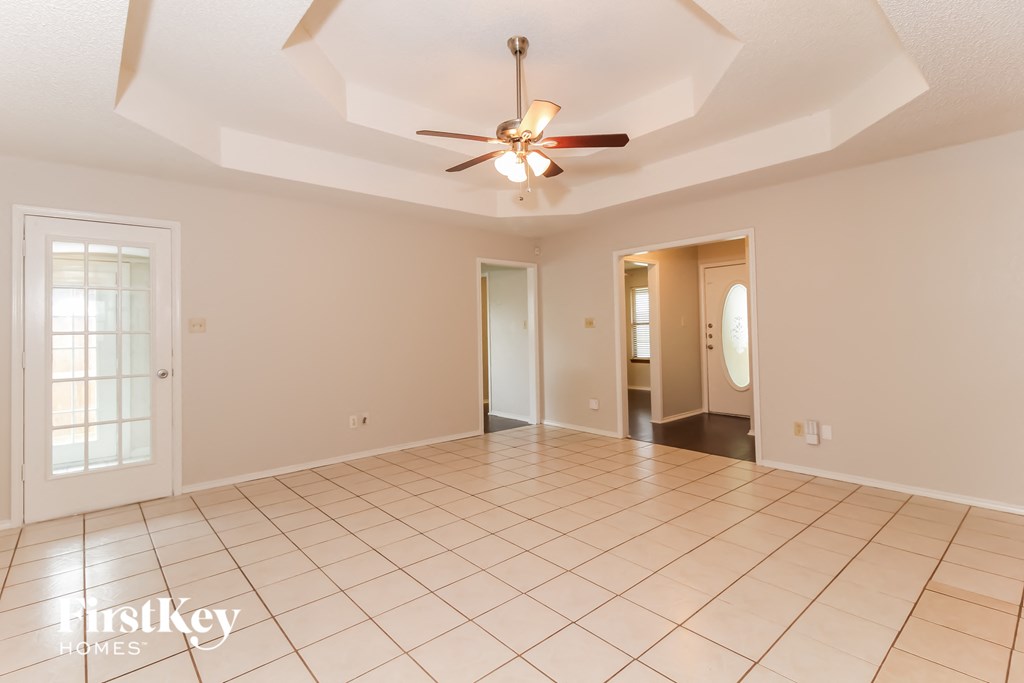 an empty living room with a ceiling fan