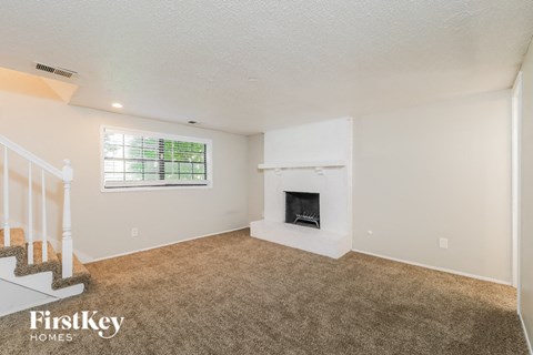 A living room with a fireplace and a window.