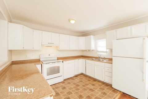 a white kitchen with white appliances and white cabinets