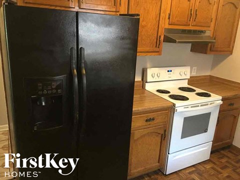 a black refrigerator in a kitchen next to a stove and