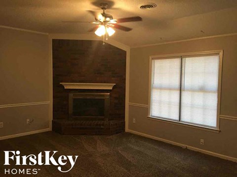 a living room with a fireplace and a ceiling fan