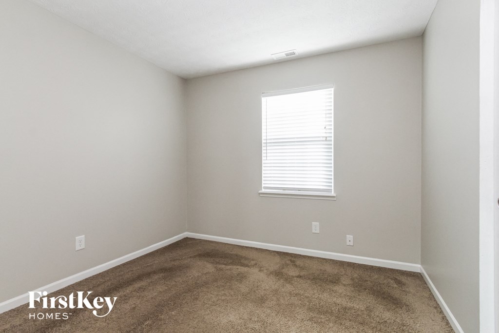 a bedroom with a carpeted floor and a window