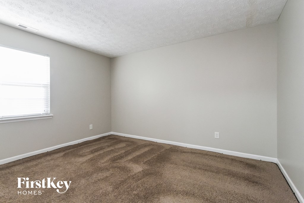 a bedroom with a carpeted floor and a window