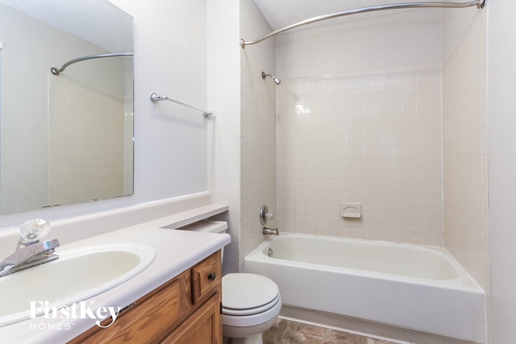 a bathroom with a white tub and a sink and a toilet