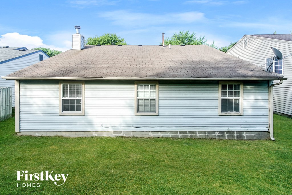 the front of a white house with a brown roof