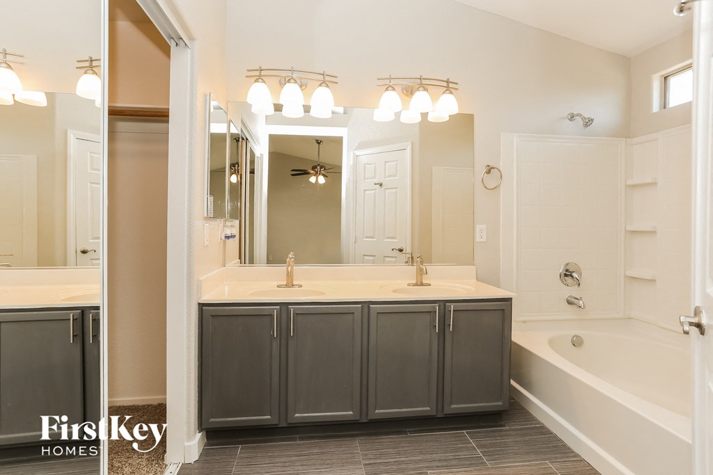 a bathroom with a sink and a tub and a mirror