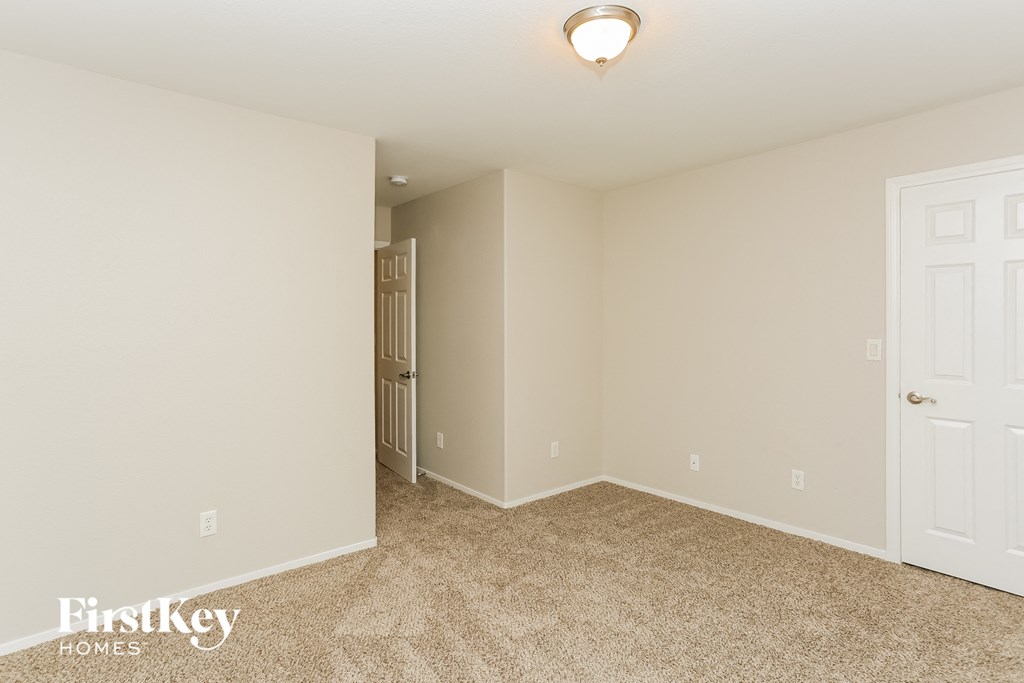 a bedroom with carpet and a door to a closet