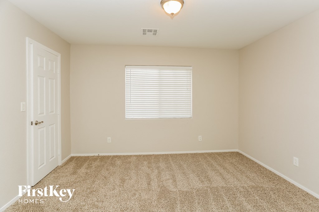a spacious room with carpet and a white door