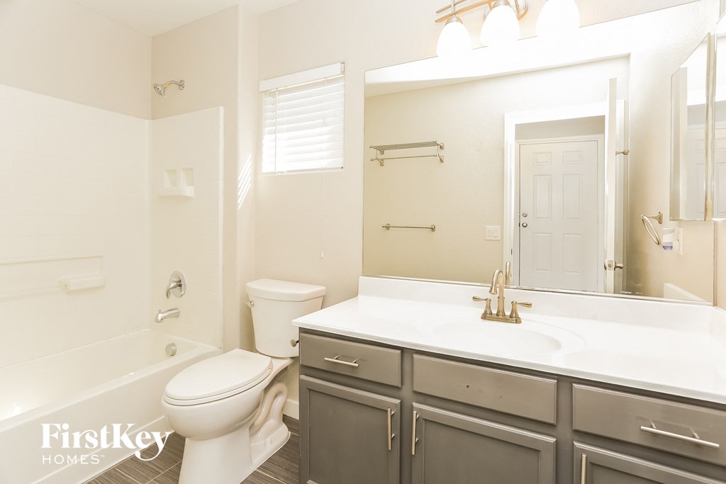 a bathroom with a sink toilet and a mirror