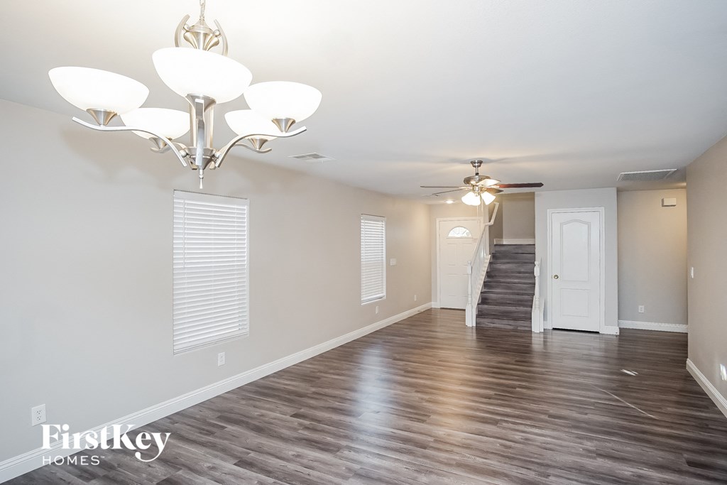 a living room with wood flooring and a chandelier