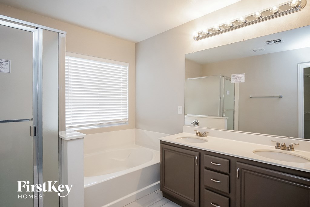 a bathroom with a tub and a sink and a mirror