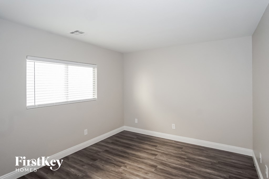 a room with wood floors and white walls and a window