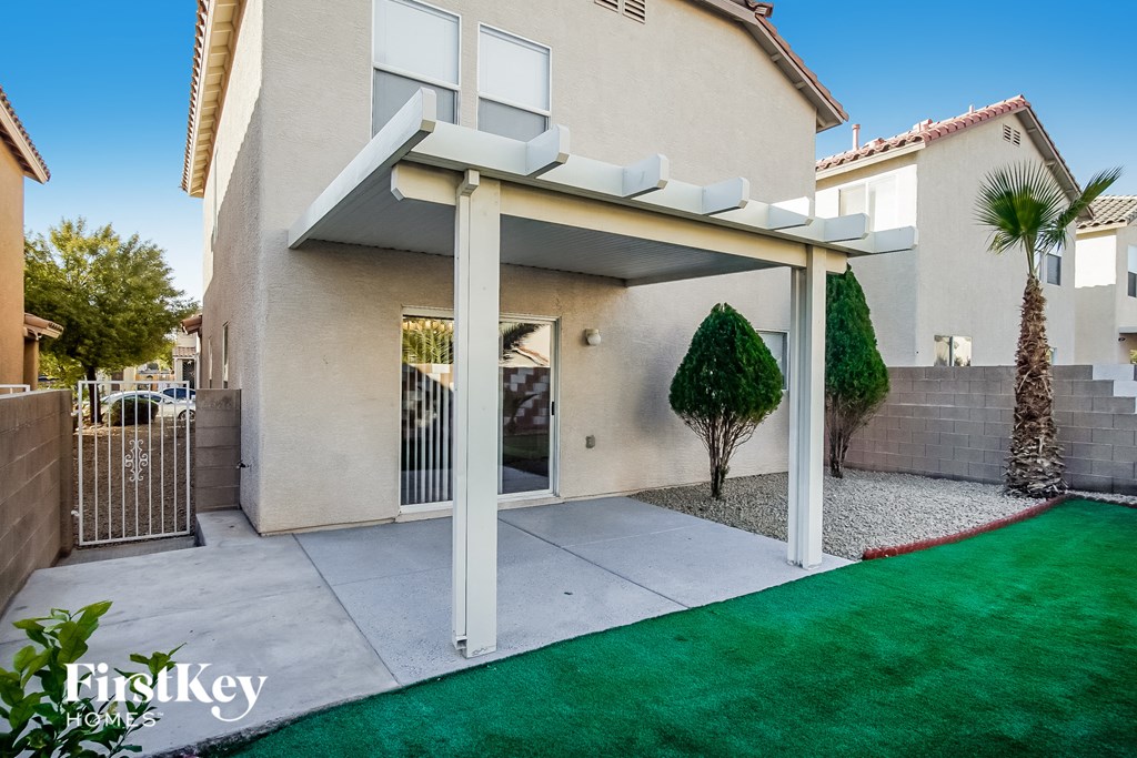 a patio in front of a house with a green lawn