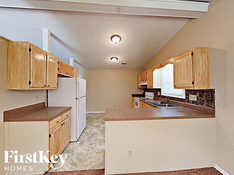 A kitchen with white appliances and wooden cabinets.