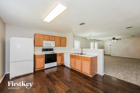 A kitchen with wooden cabinets and a white fridge.